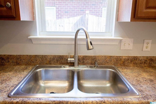 interior details with brown cabinetry and a sink