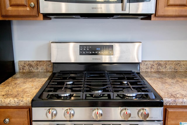 details with brown cabinetry, stainless steel range with gas stovetop, and light countertops