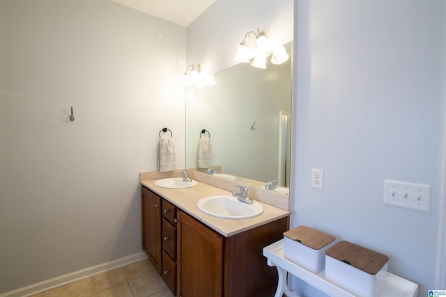 bathroom with a sink, baseboards, double vanity, and tile patterned floors