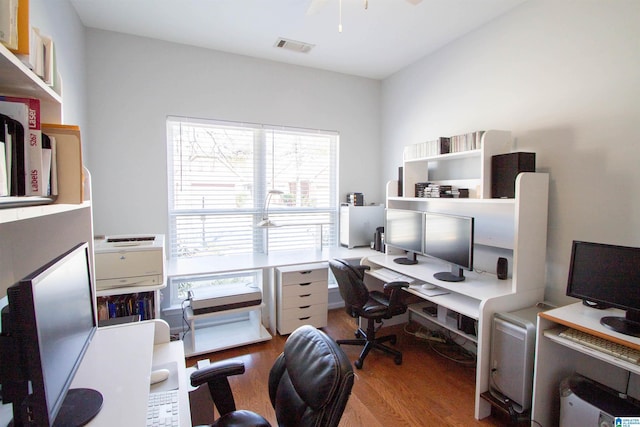 office space featuring a ceiling fan, wood finished floors, and visible vents