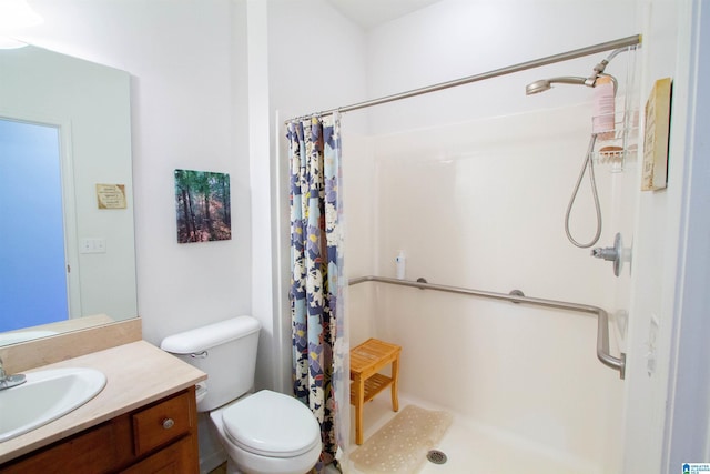 bathroom featuring vanity, a shower stall, and toilet