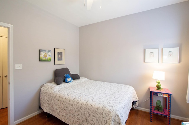 bedroom featuring baseboards, wood finished floors, and a ceiling fan