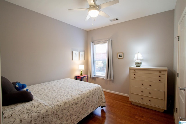 bedroom featuring a ceiling fan, visible vents, dark wood-style flooring, and baseboards