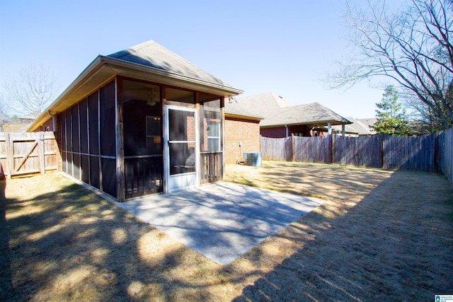 rear view of house with a patio, central air condition unit, a fenced backyard, and a sunroom