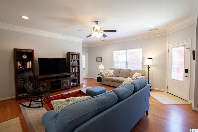 living area with visible vents, crown molding, baseboards, ceiling fan, and wood finished floors