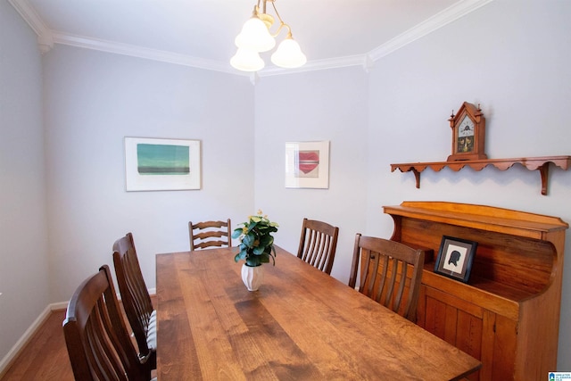 dining room with wood finished floors, baseboards, an inviting chandelier, and ornamental molding