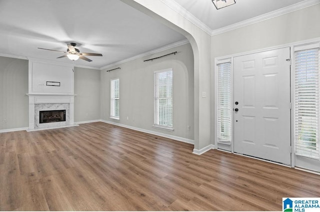 foyer with a wealth of natural light, crown molding, a ceiling fan, and wood finished floors