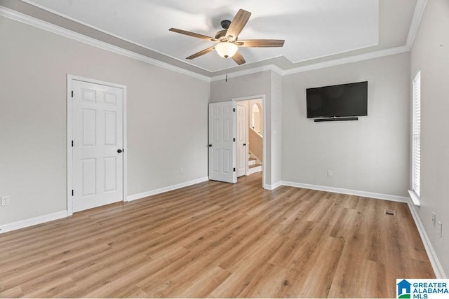 unfurnished bedroom with light wood-type flooring, baseboards, a ceiling fan, and crown molding