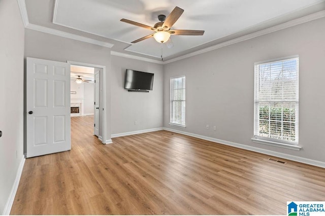 unfurnished room with visible vents, light wood-style flooring, crown molding, and ceiling fan