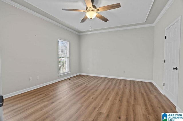 empty room featuring crown molding, wood finished floors, baseboards, and ceiling fan