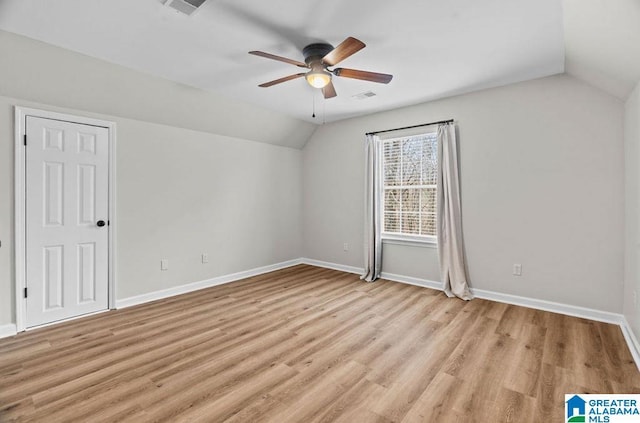 interior space with visible vents, baseboards, lofted ceiling, light wood-style flooring, and a ceiling fan