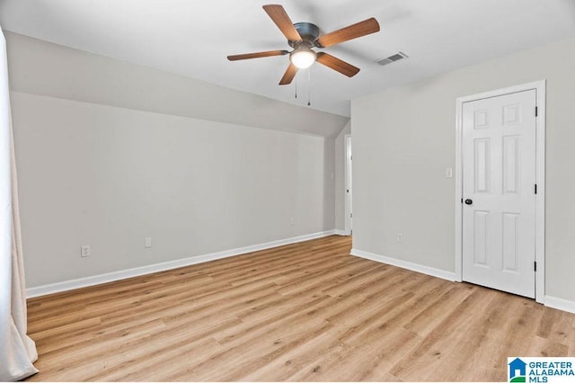 unfurnished bedroom featuring visible vents, lofted ceiling, a ceiling fan, wood finished floors, and baseboards