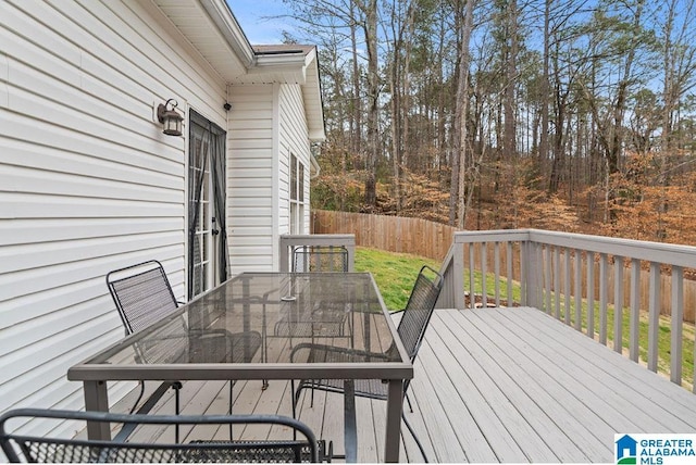 deck featuring outdoor dining area and fence