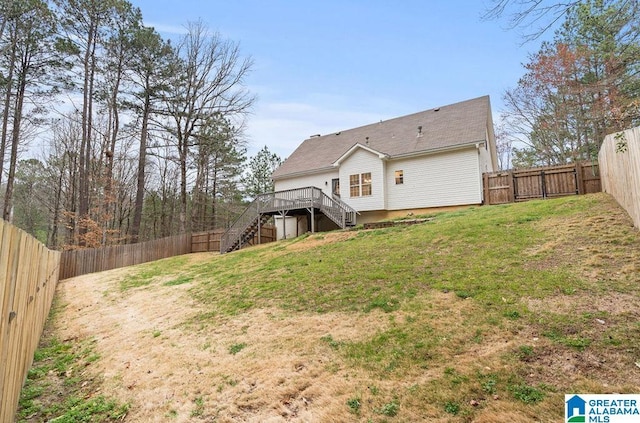 back of house with a yard, stairs, and a fenced backyard