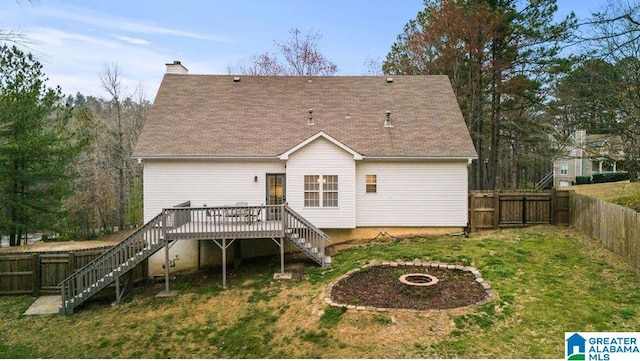 back of house with an outdoor fire pit, a fenced backyard, a chimney, stairs, and a deck