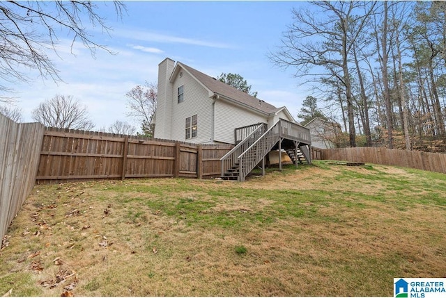 exterior space with stairs, a deck, and a fenced backyard