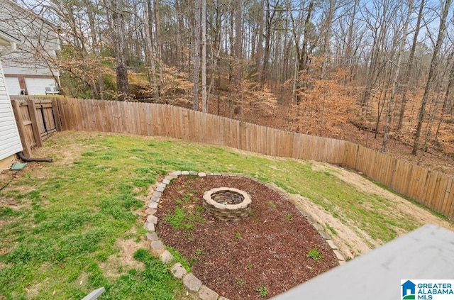 view of yard featuring a fire pit and a fenced backyard