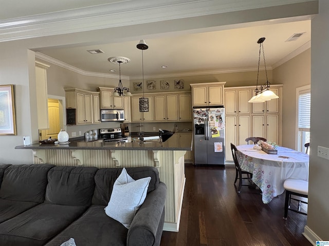 kitchen with dark countertops, dark wood-type flooring, open floor plan, appliances with stainless steel finishes, and cream cabinetry