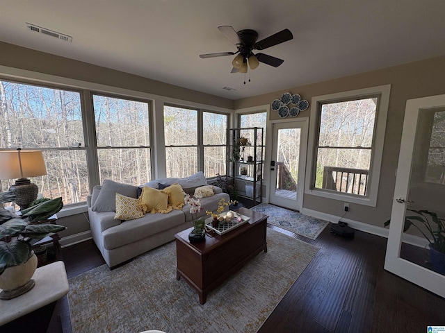 living area with baseboards, visible vents, wood-type flooring, and ceiling fan