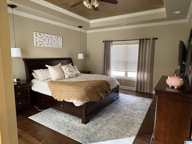 bedroom with a raised ceiling, crown molding, dark wood-type flooring, and visible vents