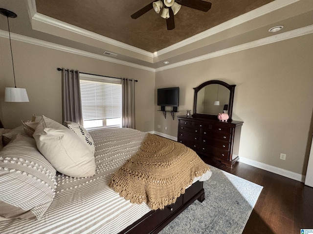 bedroom featuring visible vents, crown molding, a tray ceiling, and wood finished floors