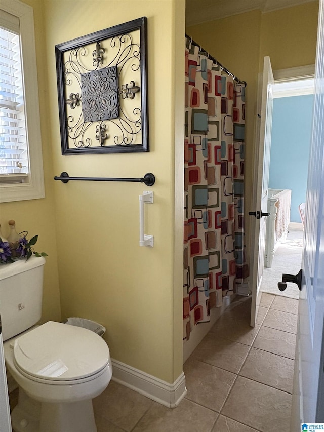 full bathroom featuring tile patterned floors, toilet, baseboards, and a shower with curtain