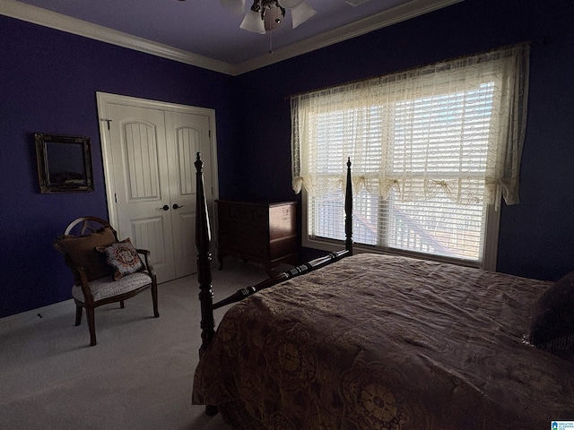 carpeted bedroom featuring a closet, a ceiling fan, and ornamental molding