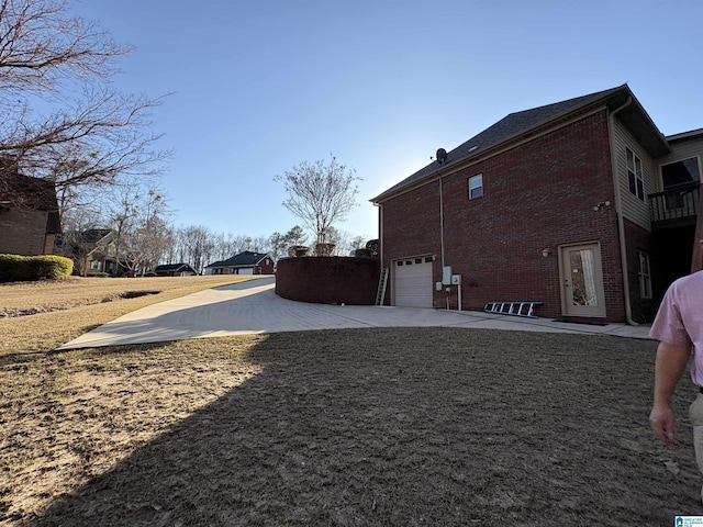 view of yard with an attached garage and driveway