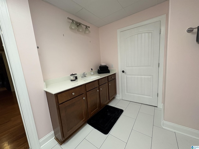 bathroom with baseboards, vanity, and tile patterned flooring