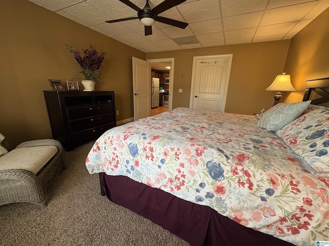 bedroom featuring ceiling fan, freestanding refrigerator, a paneled ceiling, and carpet floors