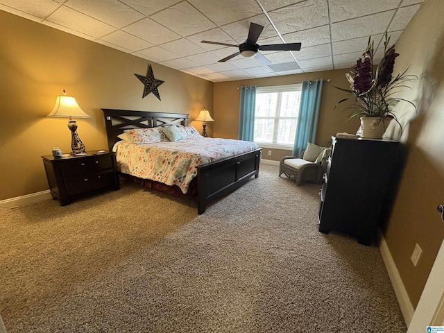 carpeted bedroom with a drop ceiling, a ceiling fan, and baseboards