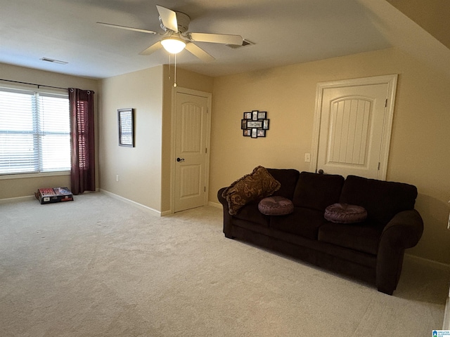 living area featuring visible vents, baseboards, carpet, and a ceiling fan