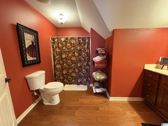 full bathroom featuring baseboards, toilet, a shower with shower curtain, lofted ceiling, and wood finished floors