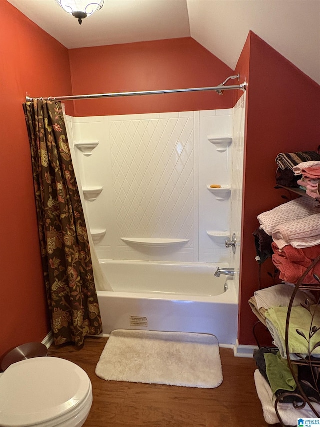 full bath featuring lofted ceiling, wood finished floors, and shower / bath combo with shower curtain