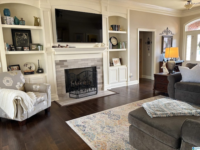 living area featuring built in features, ornamental molding, a fireplace, and hardwood / wood-style flooring