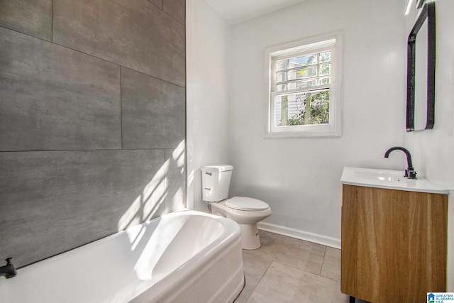 bathroom with vanity, baseboards, tile patterned floors, toilet, and a washtub