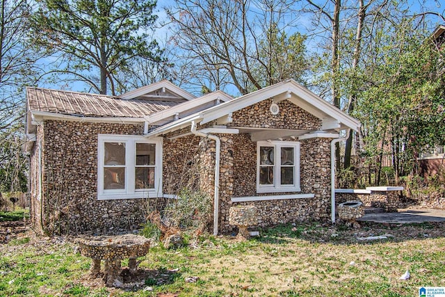 view of front facade with stone siding and metal roof