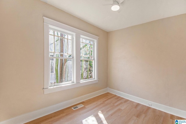 unfurnished room featuring baseboards, visible vents, and light wood finished floors