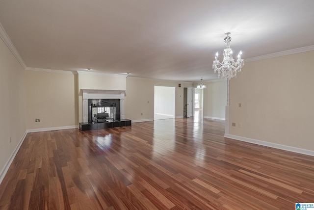 unfurnished living room featuring a tile fireplace, baseboards, an inviting chandelier, and wood finished floors