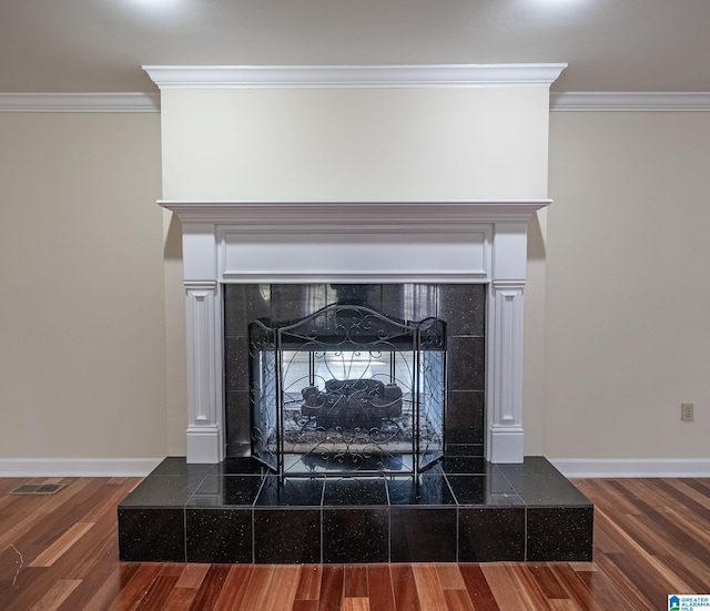 details featuring a fireplace, wood finished floors, baseboards, and ornamental molding