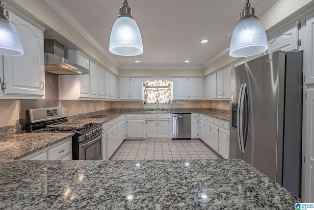 kitchen featuring white cabinetry, crown molding, wall chimney range hood, and appliances with stainless steel finishes