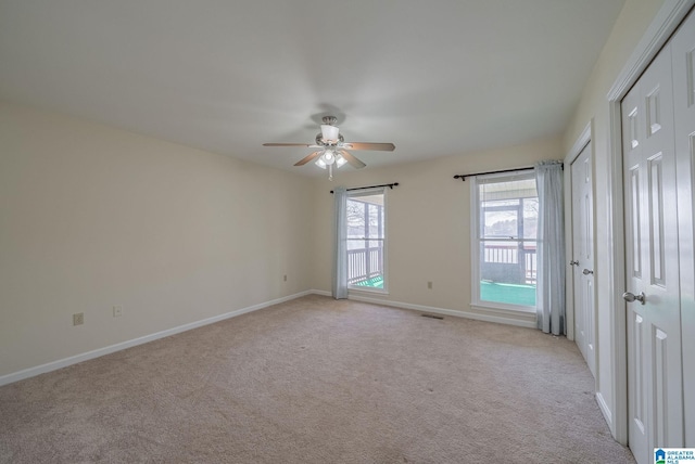 spare room featuring visible vents, baseboards, light colored carpet, and ceiling fan