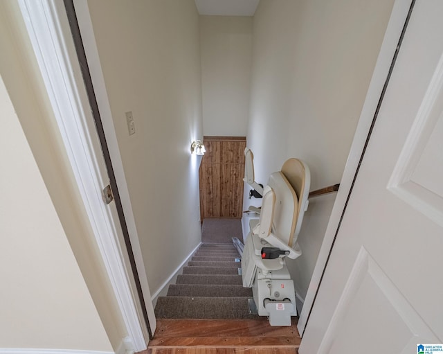 staircase featuring baseboards and wood finished floors