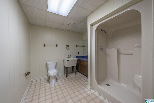 bathroom featuring tile patterned floors, a paneled ceiling, toilet, and a stall shower