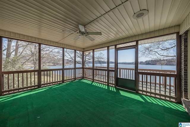 unfurnished sunroom featuring a water view and a ceiling fan