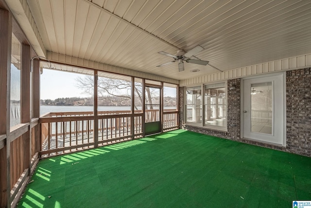 unfurnished sunroom featuring a water view, wood ceiling, and a ceiling fan