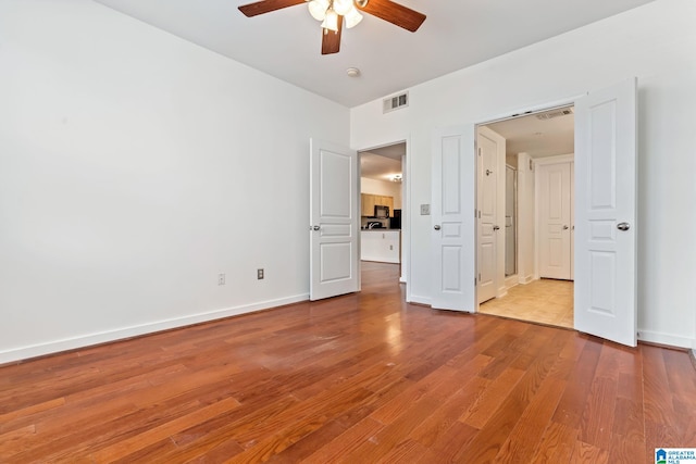 401 20th St S Unit 309, Birmingham, AL 35233 - unfurnished bedroom featuring visible vents, a ceiling fan, baseboards, and wood finished floors