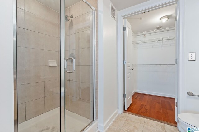 401 20th St S Unit 309, Birmingham, AL 35233 - bathroom featuring a shower stall, a spacious closet, toilet, and visible vents