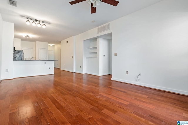 401 20th St S Unit 309, Birmingham, AL 35233 - unfurnished living room with visible vents, baseboards, ceiling fan, and wood finished floors