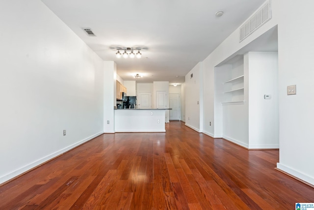 401 20th St S Unit 309, Birmingham, AL 35233 - unfurnished living room with visible vents, baseboards, and dark wood-style floors